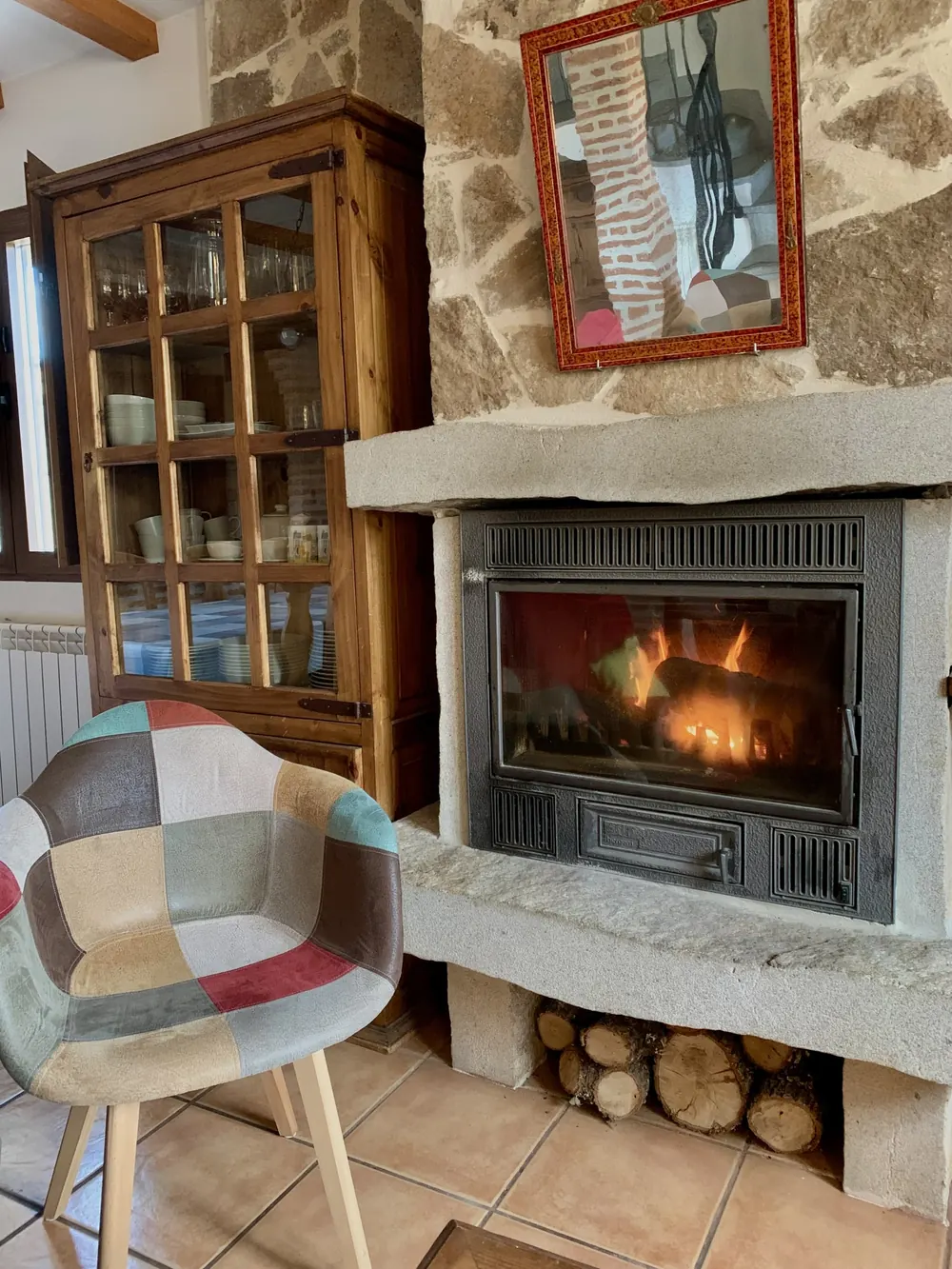 Chimenea encendida junto a la vitrina de madera del salón