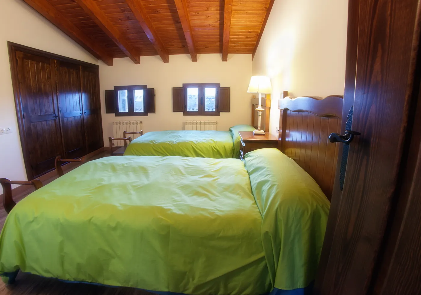 Habitación con dos camas bajo techo de vigas de madera