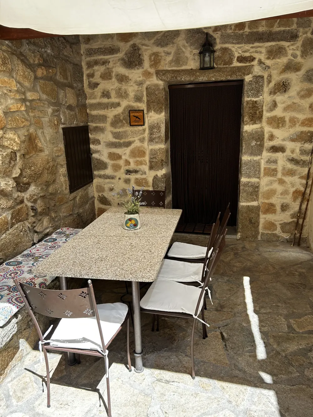 Patio de piedra con mesa y sillas al aire libre